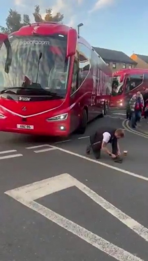 上嘴臉??利物浦大巴離開(kāi)時(shí)，一名水晶宮球迷故意蹲在車(chē)前系鞋帶